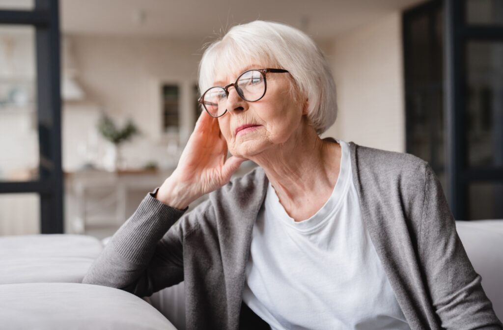 A senior woman with dementia staring out the window.